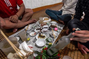 Men drink alcohol and eat dog meat at a dog meat restaurant. 
